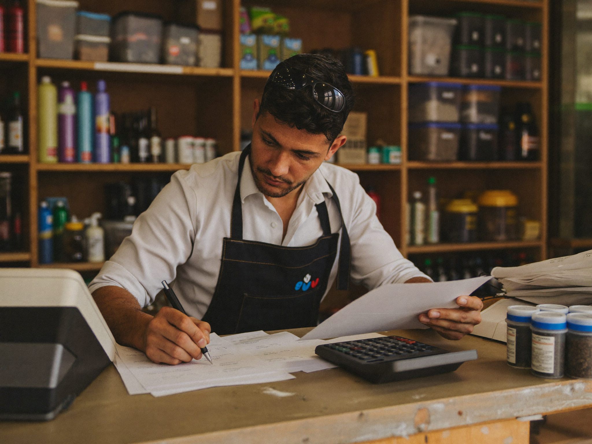 Dono de loja de material de construção revisando notas no balcão